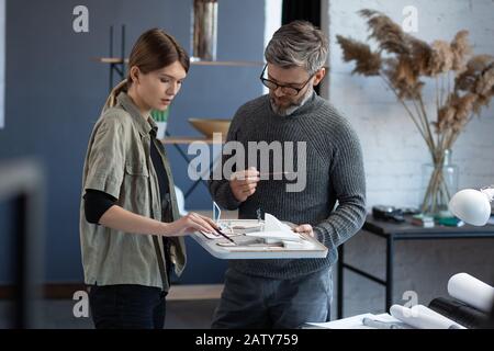 3d architects team working in office with building 3d model. Architects inspect building layout, planning construction project, searching new ideas. P Stock Photo