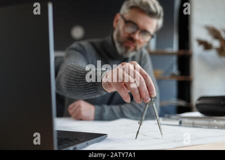 Interior designer working in office with blueprints.Engineer inspect architectural plan, sketching a construction project.Portrait of handsome bearded Stock Photo