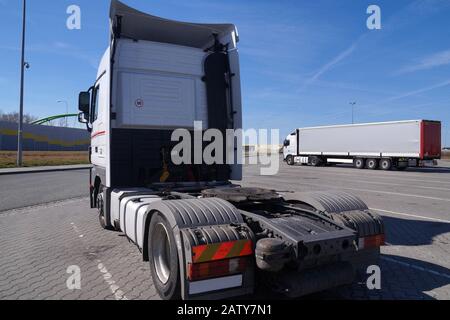 In the foreground a tractor without a semi-trailer. Trucks on the parking square. Stock Photo