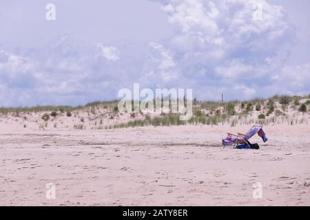 Isolated beach chair covered with a beach towel on Rehoboth Beach, Delaware Stock Photo