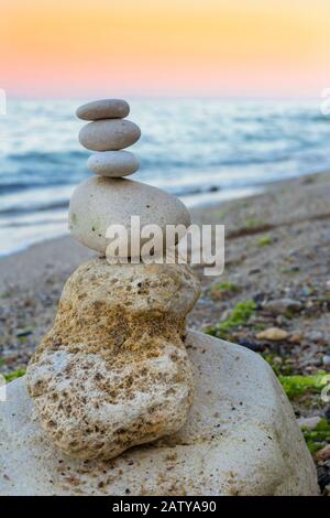 Relax time. Sunset at black sea. Rocky coast near Varna in Bulgarian. Stack of pebbles. Stock Photo