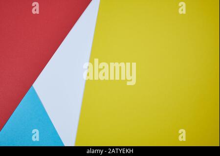 red, blue, white and yellow paper laid together in a pattern as photo background Stock Photo