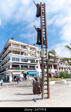 The sculpture called 'In Search of Reason' by Sergio Bustamante (2000) shows figures climbing up a ladder, Puerto Vallarta. AKA En Busca de la Razón. Stock Photo