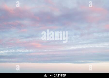 Idyllic vanilla sky of pastel pink and blue colors. Evening sky and clouds as tranquil background. Sweet candy heaven. Beauty in nature. Stock Photo
