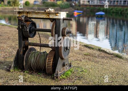 An old rusty Barge winch next to a canal used as part of an old canal lock Stock Photo
