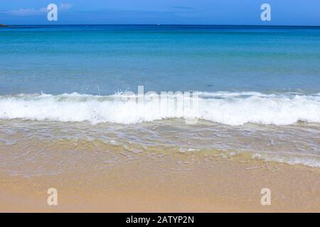 A tropical looking photo of a Cornwall beach and sea with beautiful blue summers sky Stock Photo