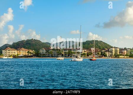 Offshore view of Rodney bay with yachts anchored in the lagoon and rich resorts in the background, Saint Lucia, Caribbean sea Stock Photo