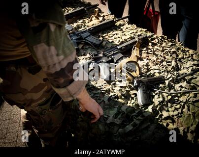Paris, France - Sep 21, 2019: French soldier near multiple semi-automatic rifle manufactured by German Heckler and Koch GmbH - military pattern background demonstration to civil persons Stock Photo