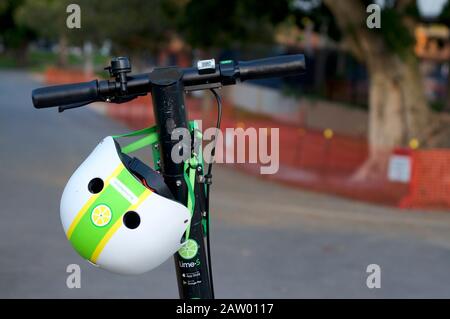 Brisbane, Queensland, Australia - 28th January 2020 : Close up of a dockless Lime e-scooter handlebars and a helmet in the city of Brisbane. This E-sc Stock Photo