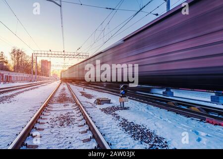 Freight train moves fast through the station. Stock Photo