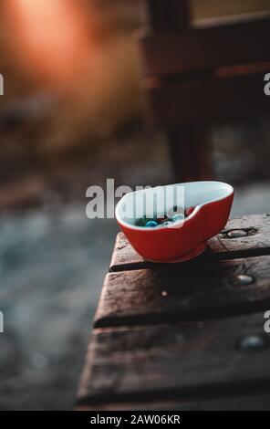 Heart shaped marble bowl on the table, marble balls inside. Background Concept. Stock Photo