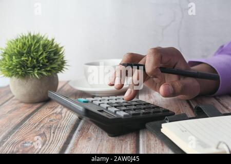 Closeup of man hand using calculator on table  Stock Photo