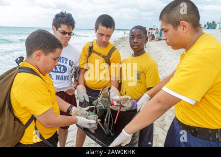 Miami Beach Florida,Coastal Cleanup Day volunteers litter trash students,US Naval Sea Cadets public beach collecting,Black Hispanic boys teen teens Stock Photo