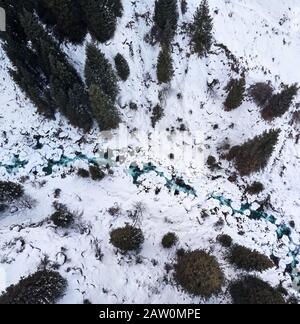 Aerial view of the river in the forest at winter time in the mountains. Drone shot, top view. Stock Photo
