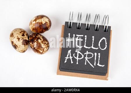 Hello April. Spring, Season, Easter and Holidays Concept. Note book and quail eggs on white background Stock Photo