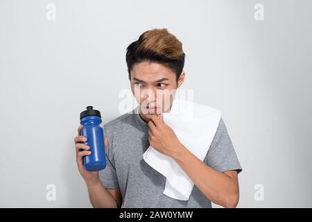 young Asian fitness man holding towel and bottle with water isolated on a white background Stock Photo