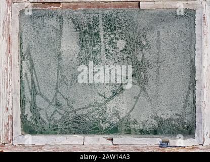 A worn out window with frost made figures on the glass surface Stock Photo