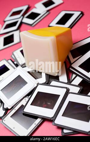 Slides and slide viewer on a pink table. Stock Photo