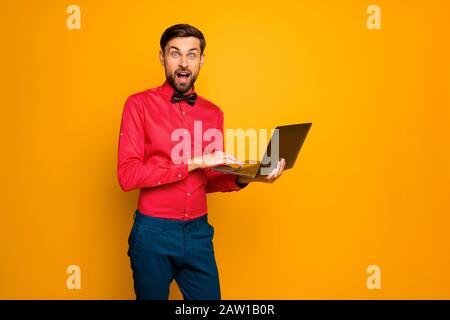 Photo of attractive business guy worker hold notebook read corporate email good news wear trendy red shirt with black bow tie blue trousers isolated Stock Photo