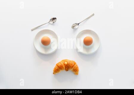 Fun breakfast concept with abstract angry grumpy human face made of breakfast items on white background Stock Photo