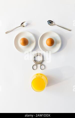Fun breakfast concept with abstract astonished human face made of breakfast items on white background Stock Photo