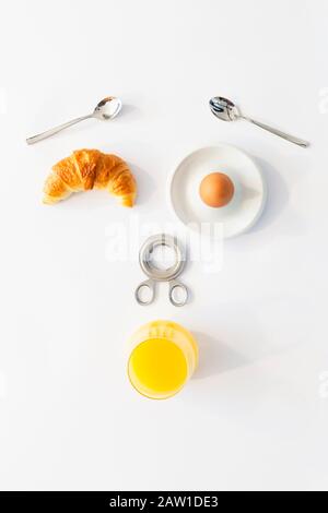Fun breakfast concept with abstract astonished human face made of breakfast items on white background Stock Photo