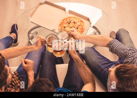 cheers! top-view photo of men celebrating and clinking glass of beer Stock Photo