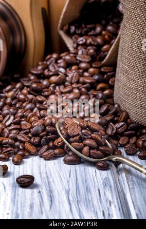 Coffee seeds in spoon with some jute bags filled with coffee and coffee grinder Stock Photo