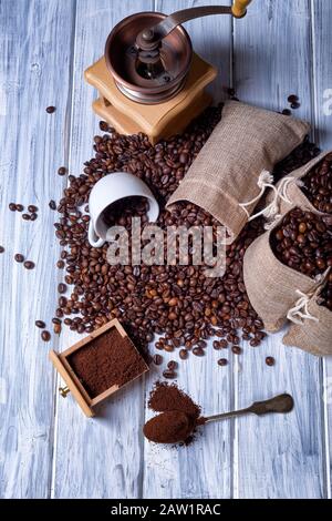 Coffee seeds in spoon with some jute bags filled with coffee and coffee grinder Stock Photo
