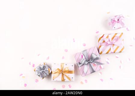 Several gift boxes with bows and confetti on a white background. Stock Photo