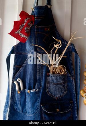 Close-up of a gardener's apron made from an old pair of denim jeans with pockets for raffia and secateurs Stock Photo