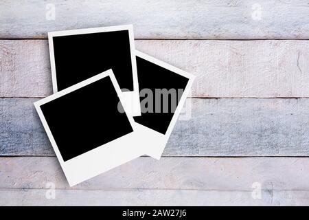 Three photo frames on a white wooden desktop. Top down view and mock up for photo gallery. Empty copy space for Editor's content. Stock Photo