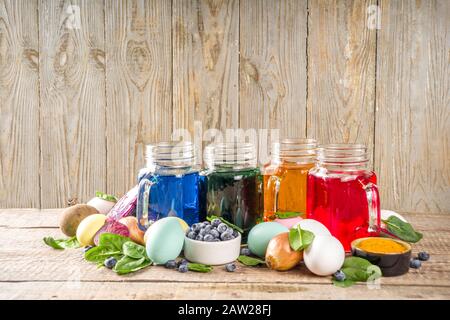 Easter organic and zero waste concept. Easter eggs painted with natural egg dye, fruits and vegetables. Wooden background Stock Photo
