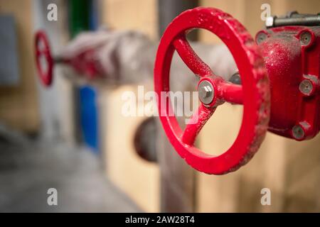 Red valves on hydrant pipelines of security and fire extinguishing systems of modern chemical production with copy space. Stock Photo