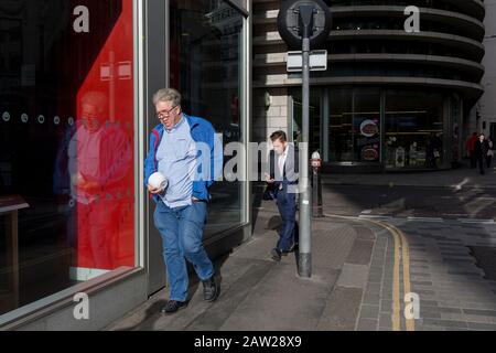 Men walk into sunshine on a breezy day in the City of London, the capital's financial district, on 4th February 2020, in the City of London, England. Stock Photo