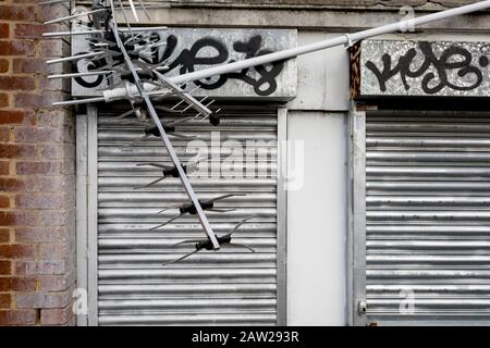 A landscape of a broken and twisted TV aerial and the metal shutters of a business opposite St. Mar Cray station, on 3rd February 2020, in London, England Stock Photo
