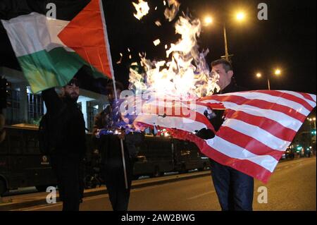 Palestinians burn a flag of the United States outside of US embassy during a rally  in Athens. Stock Photo
