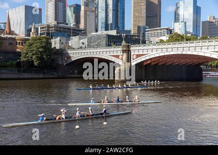 Yarra river melbourne, teenage girls in rowing boats training on the river and Princes bridge in Melbourne city centre,Victoria,Australia Stock Photo