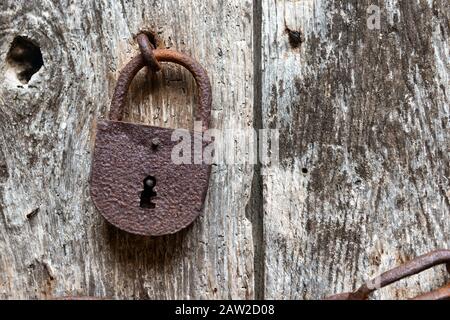 old rusty closed lock on an ancient wooden door Stock Photo