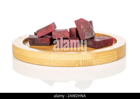 Lot of pieces of raw sweet beetroot on round bamboo coaster isolated on white background Stock Photo