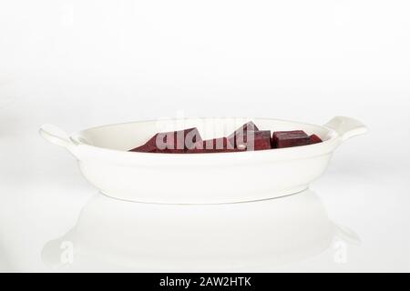 Lot of pieces of raw sweet beetroot on white ceramic plate isolated on white background Stock Photo