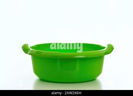 Cleaning wash bowl, plastic hand basin green color isolated against white background, Domestic household cleaning Stock Photo