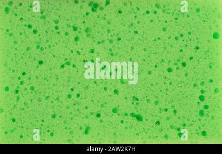 Sponge texture background. Green color cleaning sponge material detail close up view. Dish washing or beauty care. Macro Stock Photo