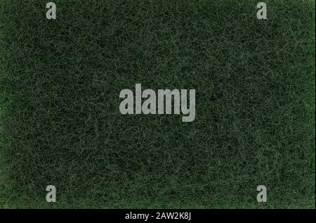 Scourer texture background. Green color cleaning scouring pad material detail close up view. Dish washing pad, Macro view Stock Photo
