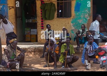 Turmi, Ethiopia - Nov 2018: Hamer tribe men with traditional stick sitting in front of the building. Omo valley Stock Photo