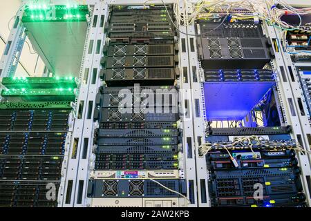 Many аccess servers are located in a modern data center. Powerful computer equipment works in the server room rack. Cloud data storage services. Botto Stock Photo