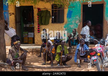 Turmi, Ethiopia - Nov 2018: Hamer tribe men with traditional stick sitting in front of the building. Omo valley Stock Photo