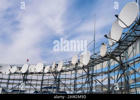 Satellite antennas installed in a circle on the iron fittings.  TV station with a lot of receiving devices. Telecommunication equipment of the telecen Stock Photo