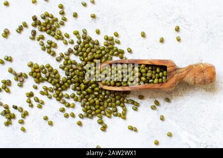 Dried mung beans with a spoon on a white background  top view