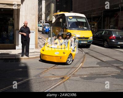 Tourists riding a GoCar rental vehicle for tours in Lisbon, Portugal Stock Photo